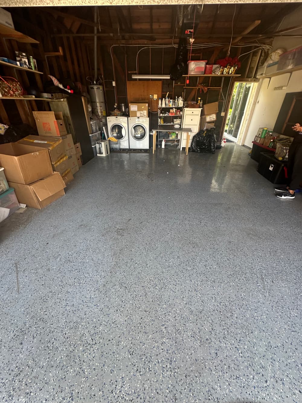 Clean garage interior with storage boxes, washer, dryer, and organized shelves.