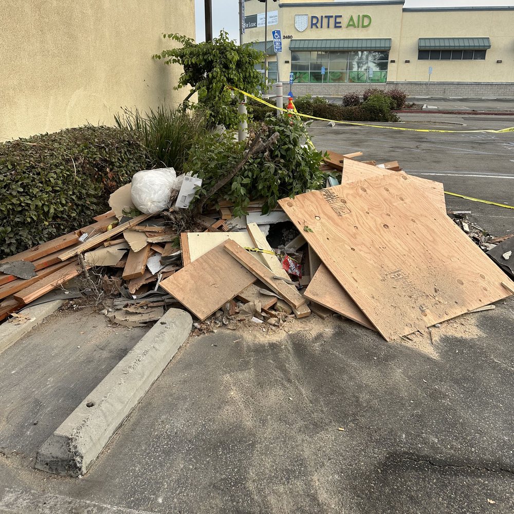 Construction debris and plywood piled outside a building