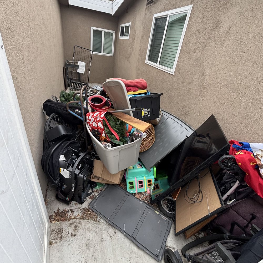 Side yard packed with bins, bags and household items