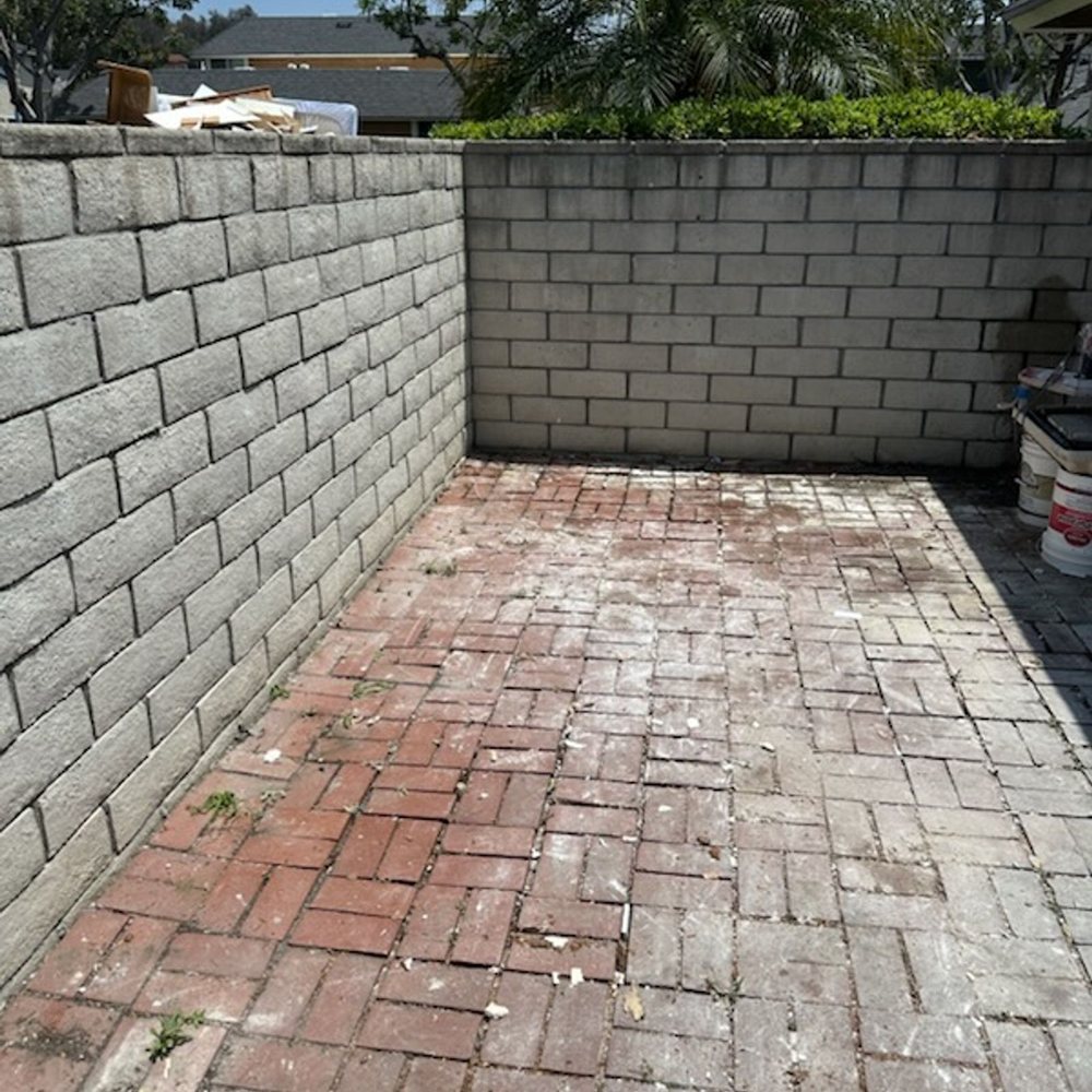 Brick patio cleared and swept after a backyard removal job