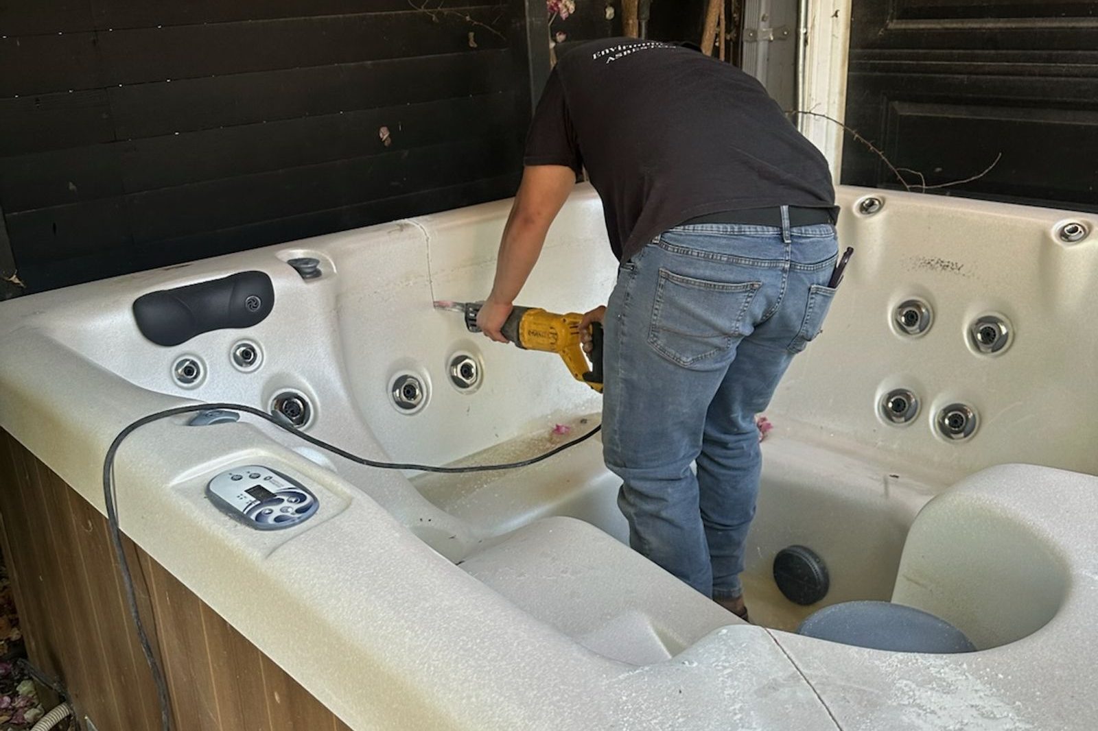 Roa Solution crew member taking apart an old hot tub in a backyard