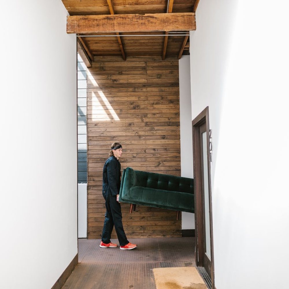 Mover carrying a sofa out of a home