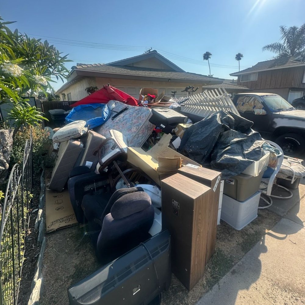 Furniture and junk piled beside cars waiting for removal