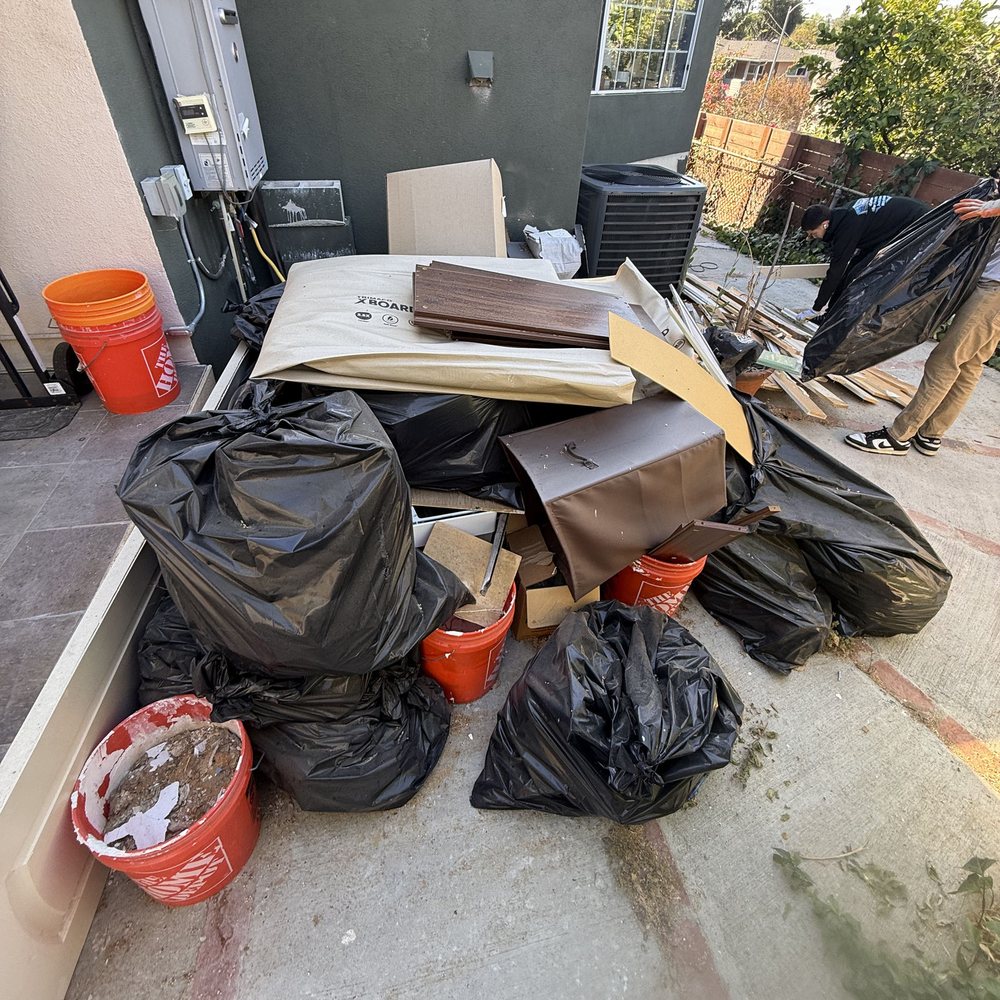 Bags, boxes and buckets piled beside a home before pickup