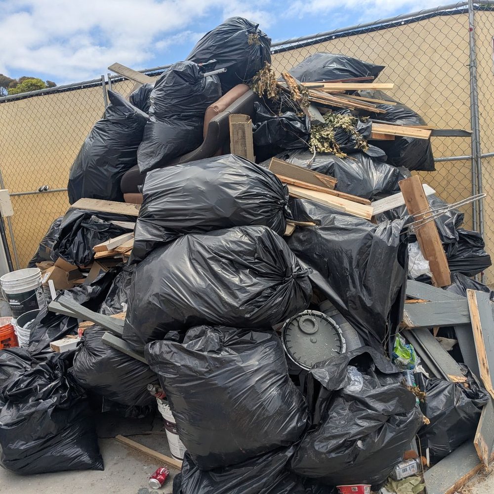 Large pile of trash bags and wood debris ready for junk removal