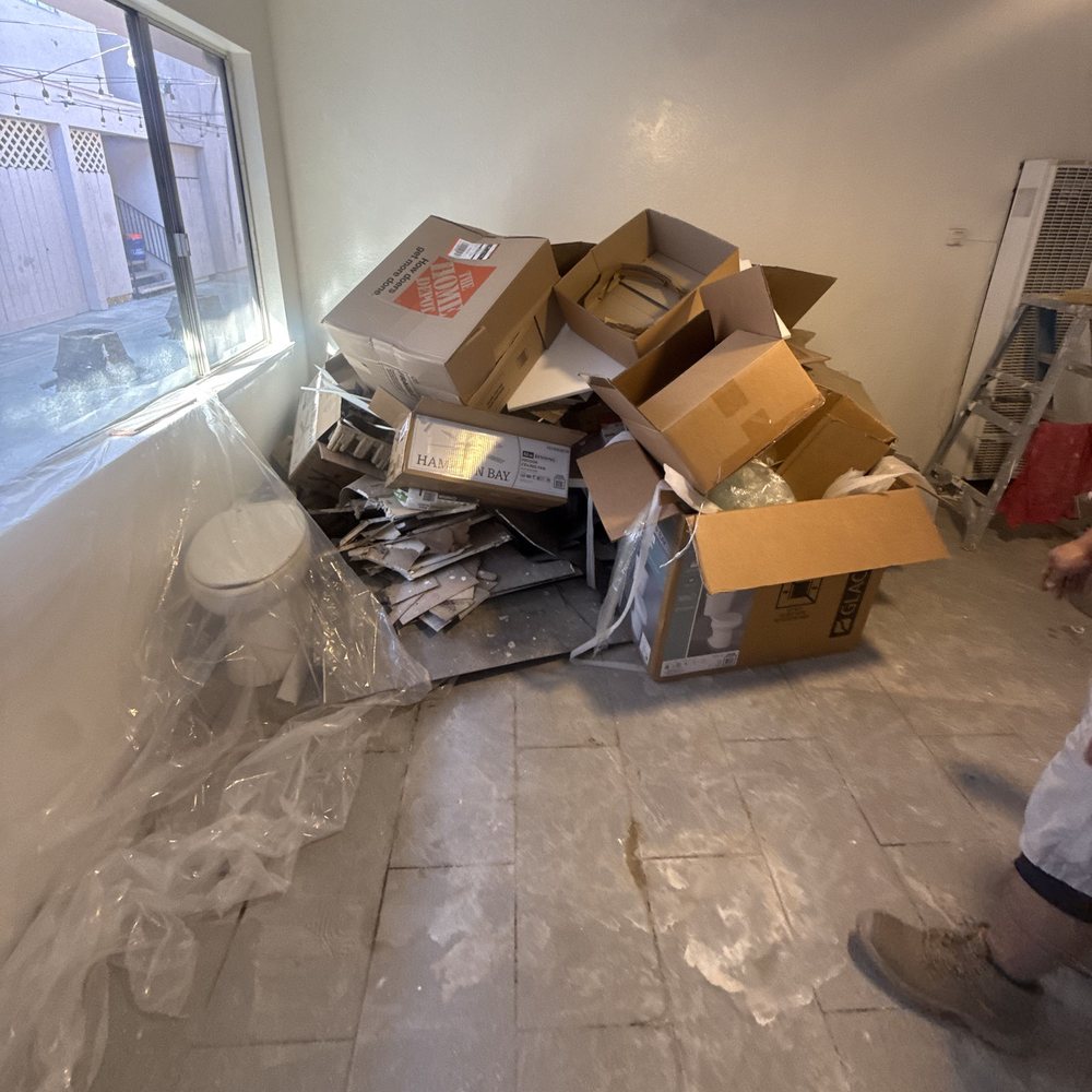 Room with stacked cardboard boxes and clutter before an office clean out