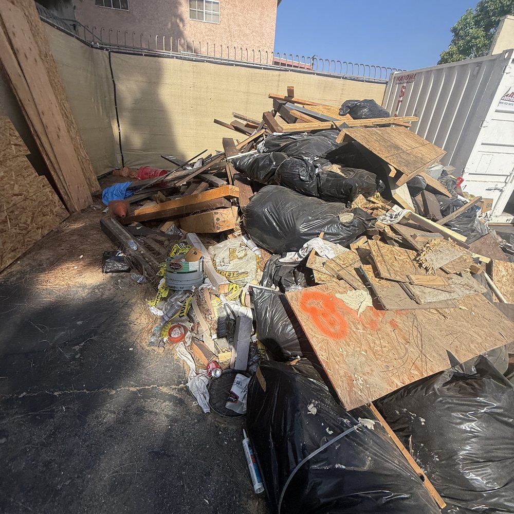 Wood debris and bagged junk piled for removal by Roa Solution