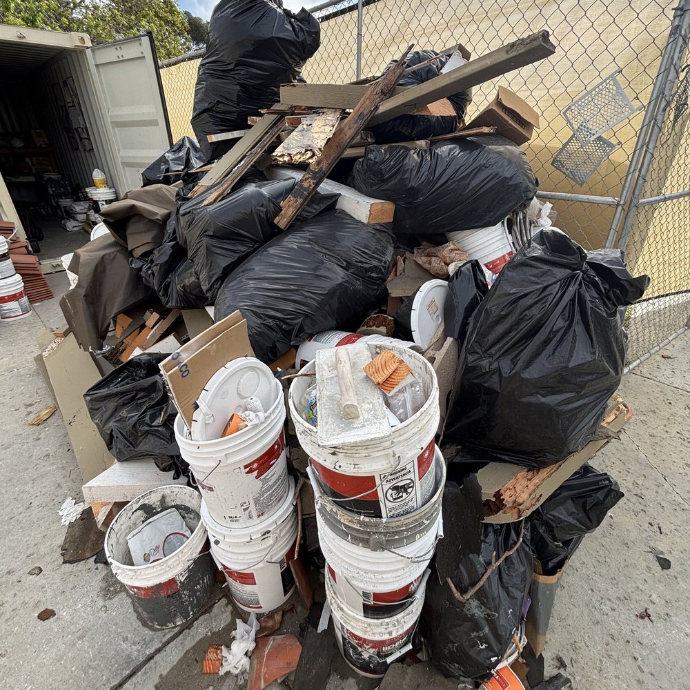 Pile of trash bags, buckets and wood waiting for junk removal