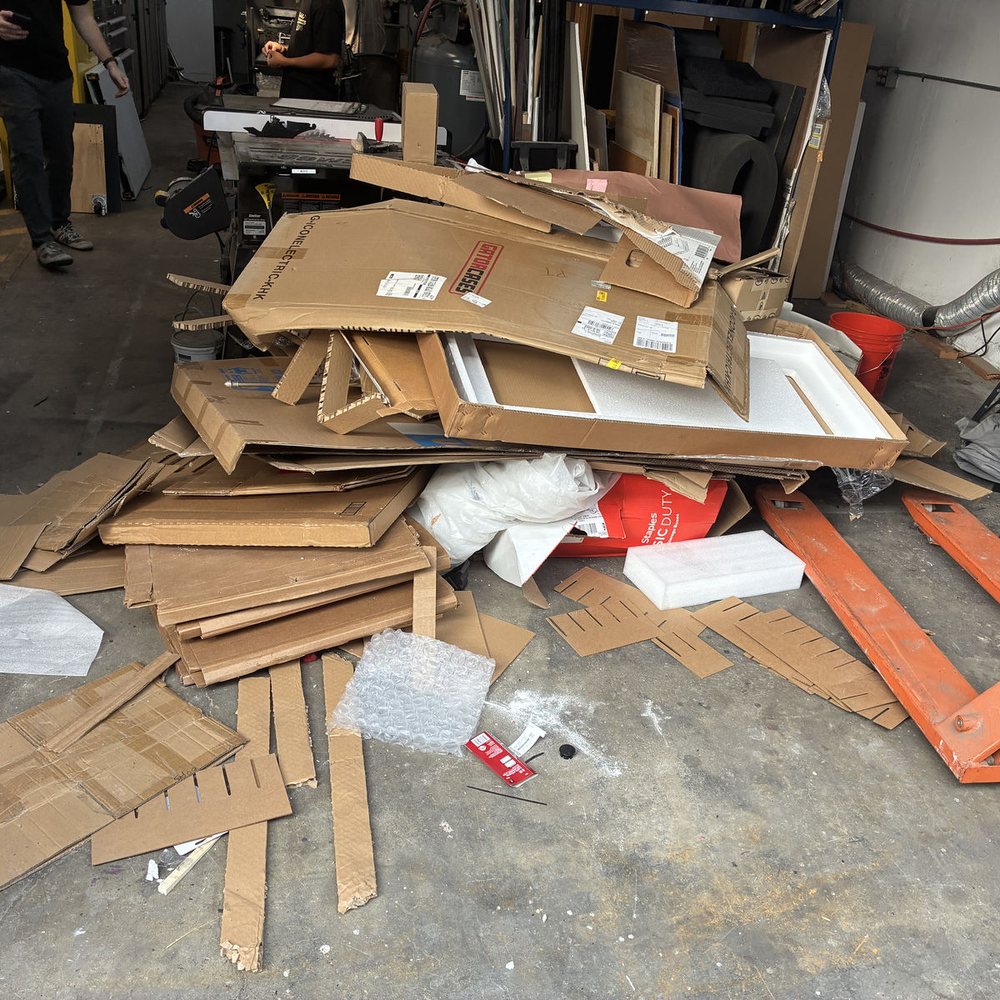 Broken-down boxes and remodel scraps on a garage floor waiting for haul-away