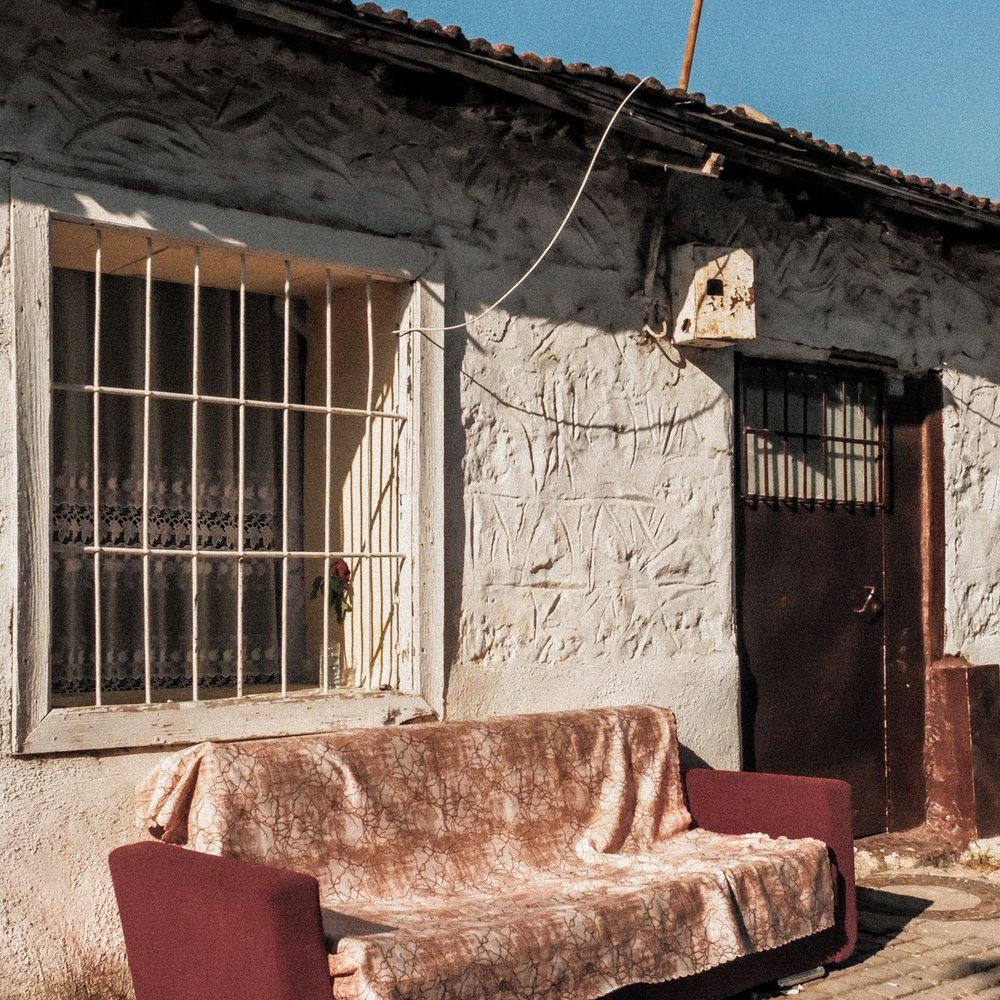 Old couch left outside a building waiting for pickup