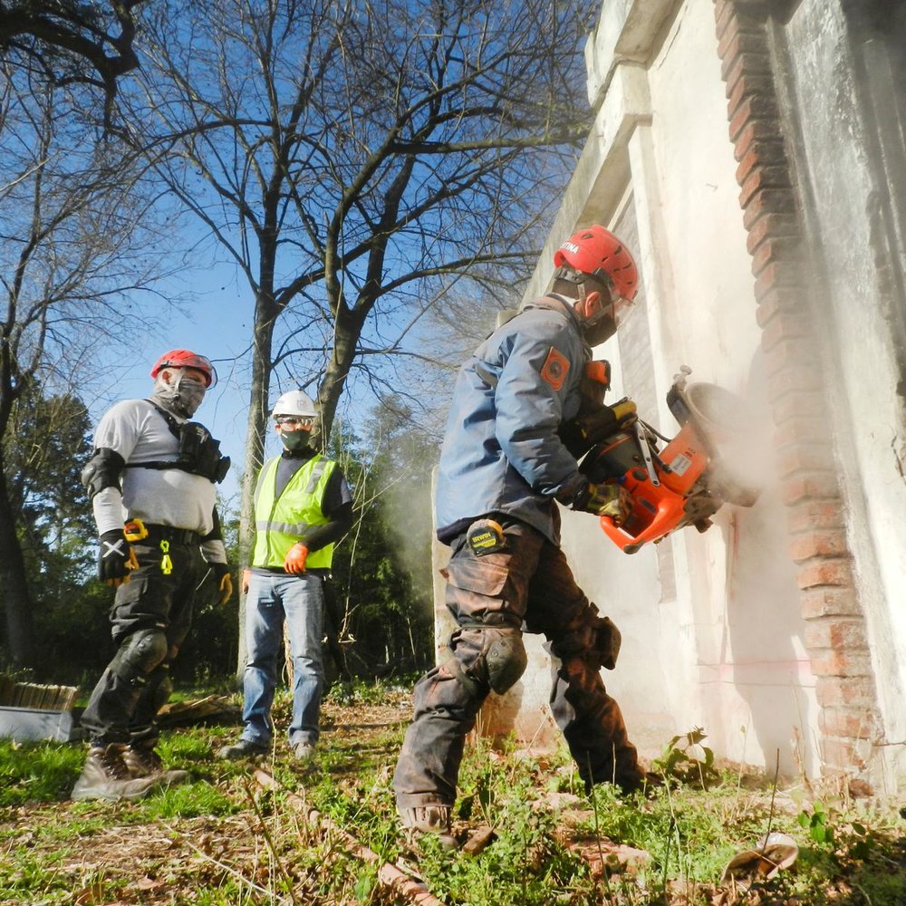 Demolition crew breaking down an exterior wall