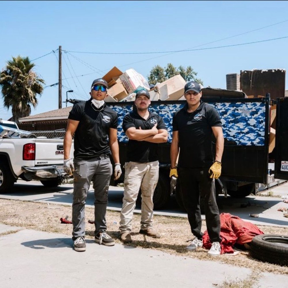 Roa Solution Junk Removal team standing in front of their truck and dump trailer